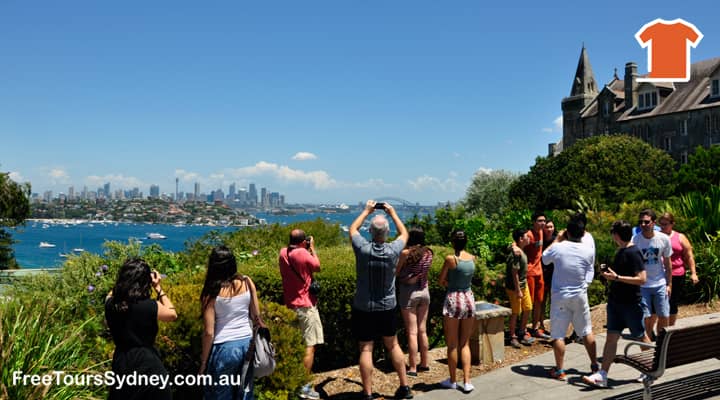 A group of tourists who joined Sydney sightseeing tours are at the lookout next to Kincoppal school at Vaucluse. Travellers are taking pictures of the City at a distance.